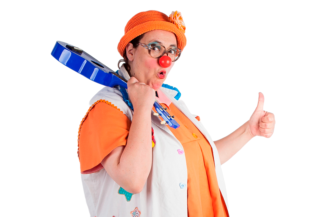 Payasa "Enfermera Mina Mercromina" sujetando un ukelele azul, con camisa y sombrero naranjas y gafas de pasta grande, haciendo un gesto de "ok".