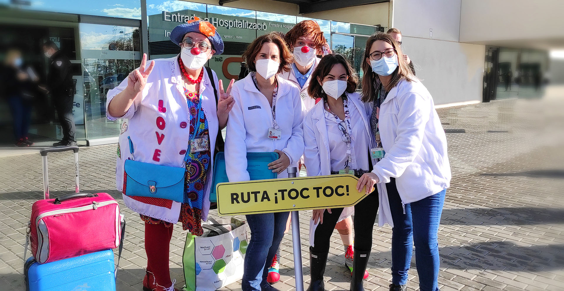 Payasospital y personal sanitario de visitas a domicilio del Hospital La Fe con rótulo: "Ruta Toc Toc"